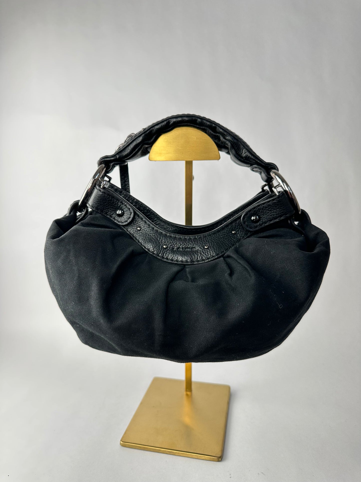 LANCEL small bag in cotton canvas and black grained leather decorated with a bell bag jewel and a signed coin, zipped handle.